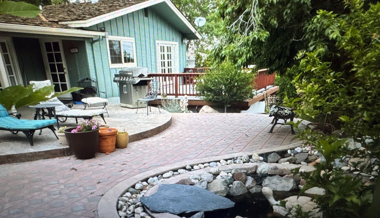 Stone paver patio with landscaping and water feature